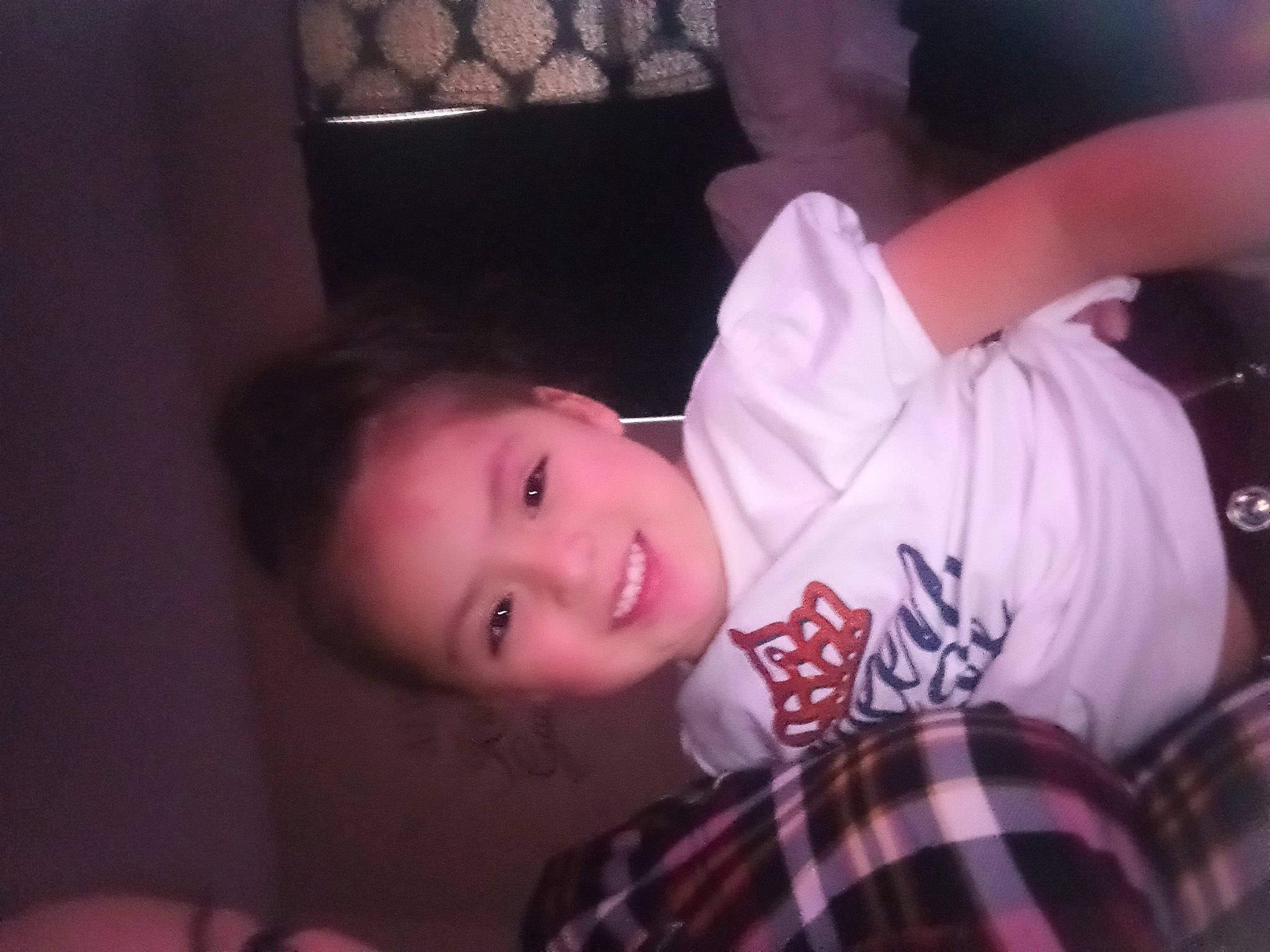 Genesis is registered to the contest to win money with this photo: baby_toddler_clothing, cheek, child, darkness, elbow, eyelash, flash_photography, fun, happy, joy, lip, magenta, mouth, nose, pattern, person, plaid, plant, smile, t_shirt