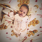 Sofia-Rose is registered to the contest to win money with this photo: baby, infant, onesie, blanket, gingerbread_man, candy_cane, milestone, sign, face, person, cute, holiday, christmas, soft_toys, lying_down, child, smiling, decor, fabric, closeup