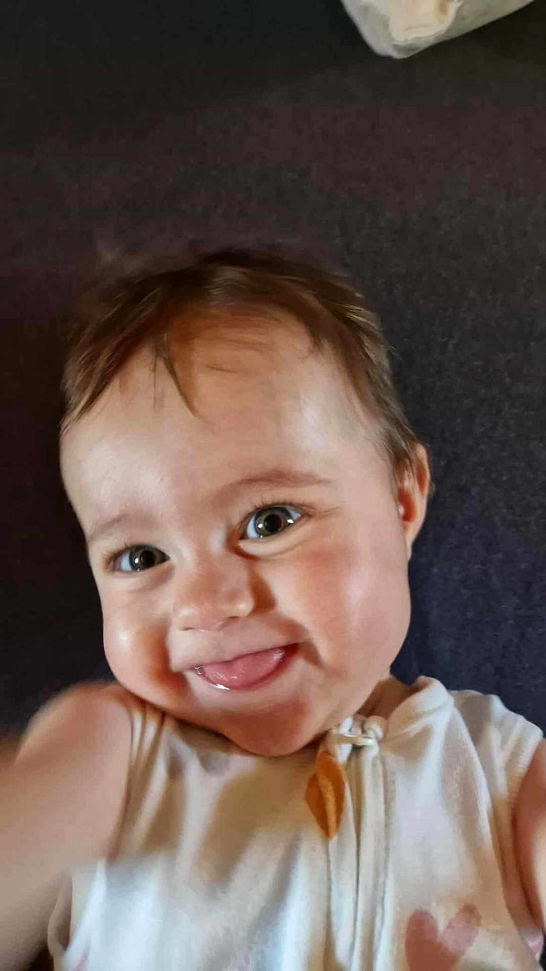 Ambre a rejoint le concours — aidez-le/la à gagner de superbes lots ! baby, child, smiling, tongue, face, eyes, white_clothing, cute, happy, portrait, infant, cheeky, closeup, baby_girl, baby_boy, soft_background, indoor, skin, head, hair