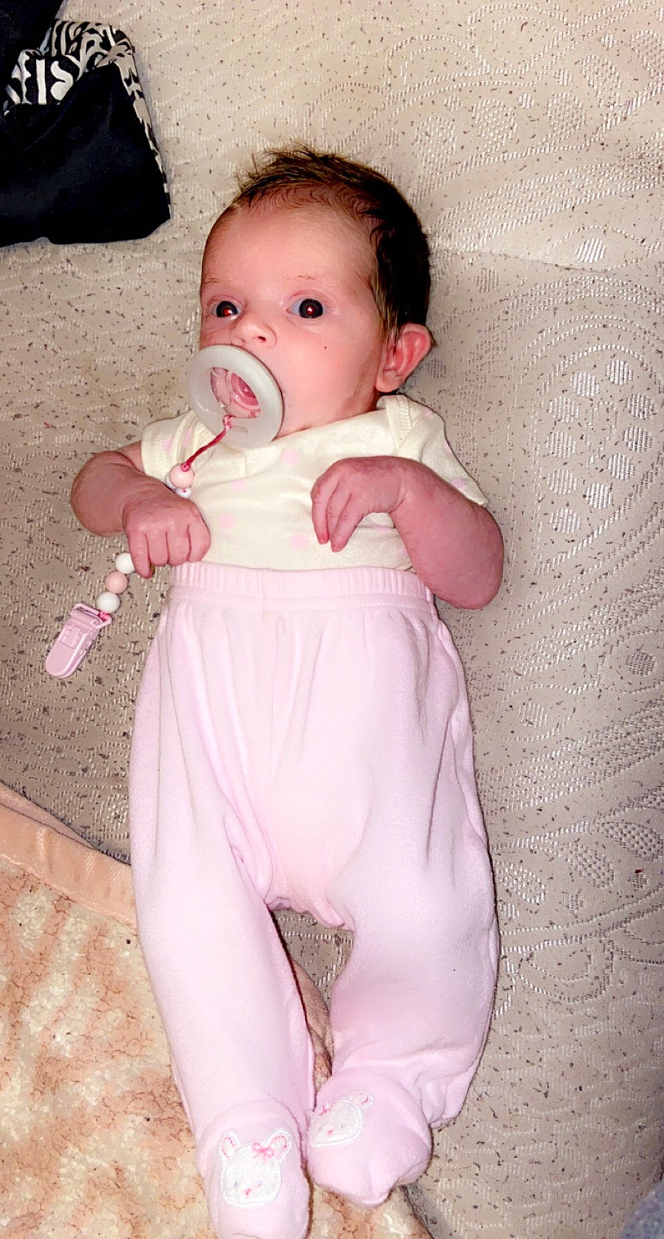 Sophie is registered to the contest to win money with this photo: arm, baby, baby_toddler_clothing, cheek, eye, gesture, hairstyle, hand, head, human_body, lip, mouth, neck, nose, person, pink, skin, sleeve, stomach, thumb