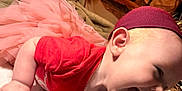 Nora is registered to the contest to win money with this photo: baby, child, tutu, pink, red_shirt, headband, laughing, toy, plush_toy, happy, candid, indoor, floor, necklace, person, cute, smile, infant, clothing, joyful