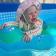 Isabella-Rayne joined the competition — help win amazing prizes! baby, blue, child, clothing, dolphin, floatie, happy, hat, infant, outdoor, pink_hat, playful, pool, sleeves, smiling, summer, sunhat, swimming_pool, toy, water