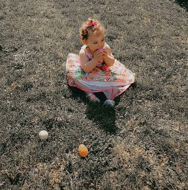 Kora is registered to the contest to win money with this photo: asphalt, baby, ball, dress, fun, grass, hair, happy, head, landscape, lawn, leisure, mammal, people_in_nature, person, recreation, road_surface, sports_equipment, toddler, toy