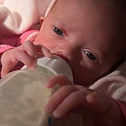 Zaza is registered to the contest to win money with this photo: baby, bottle, feeding, infant, pink_blanket, headband, close_up, hand, milk, newborn, sleeping_area, soft_toys, indoor, cute, child, person, portrait, warm_lighting, comfort, rest