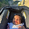 baby, child, infant, stroller, smiling, sleeping, outdoor, travel, bridge, waterfall, stone_architecture, nature, sunlight, portrait, dress, pacifier, toy, seated, tourist_attraction, family_outing
