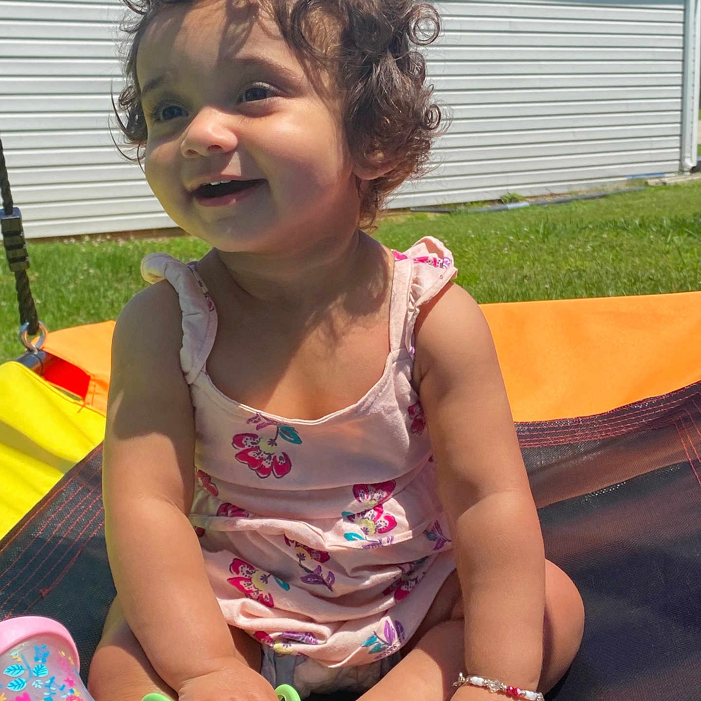 Baeleigh Rain is registered to the contest to win money with this photo: baby, bracelet, candid, child, curly_hair, dress, fun, grass, happy, nature, outdoor, person, playtime, sippy_cup, smile, summer, sunlight, swing, toddler, toy