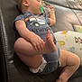 Bentley is registered to the contest to win money with this photo: baby, sleeping, pacifier, couch, leather, toy, foot, hand, diaper, onesie, indoor, child, infant, pillow, animal_print, floor, wood_floor, peaceful, relaxed, home