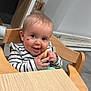 Mia a rejoint le concours — aidez-le/la à gagner de superbes lots ! baby, child, high_chair, food, snack, smiling, face, hands, heart_sticker, striped_clothing, indoor, wooden_furniture, table, happy, cute, portrait, person, young_child, messy, eating