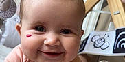 Mia a rejoint le concours — aidez-le/la à gagner de superbes lots ! baby, infant, smile, face, heart_mark, play_mat, toy, soft_toy, clothing, baby_gym, child, cute, indoors, happy, person, skin, head, arm, closeup, expression