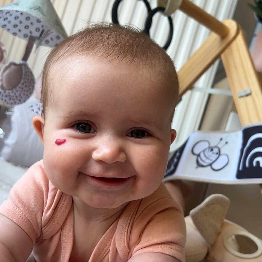 Mia a rejoint le concours — aidez-le/la à gagner de superbes lots ! arm, baby, baby_gym, child, closeup, clothing, cute, expression, face, happy, head, heart_mark, indoors, infant, person, play_mat, skin, smile, soft_toy, toy