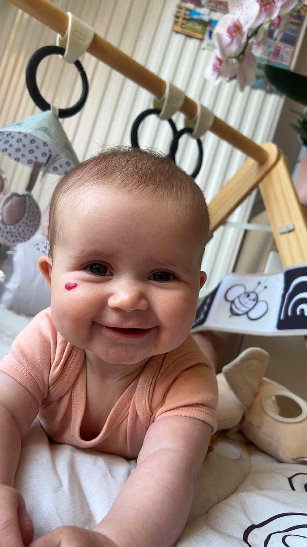 Mia a rejoint le concours — aidez-le/la à gagner de superbes lots ! baby, infant, smile, face, heart_mark, play_mat, toy, soft_toy, clothing, baby_gym, child, cute, indoors, happy, person, skin, head, arm, closeup, expression