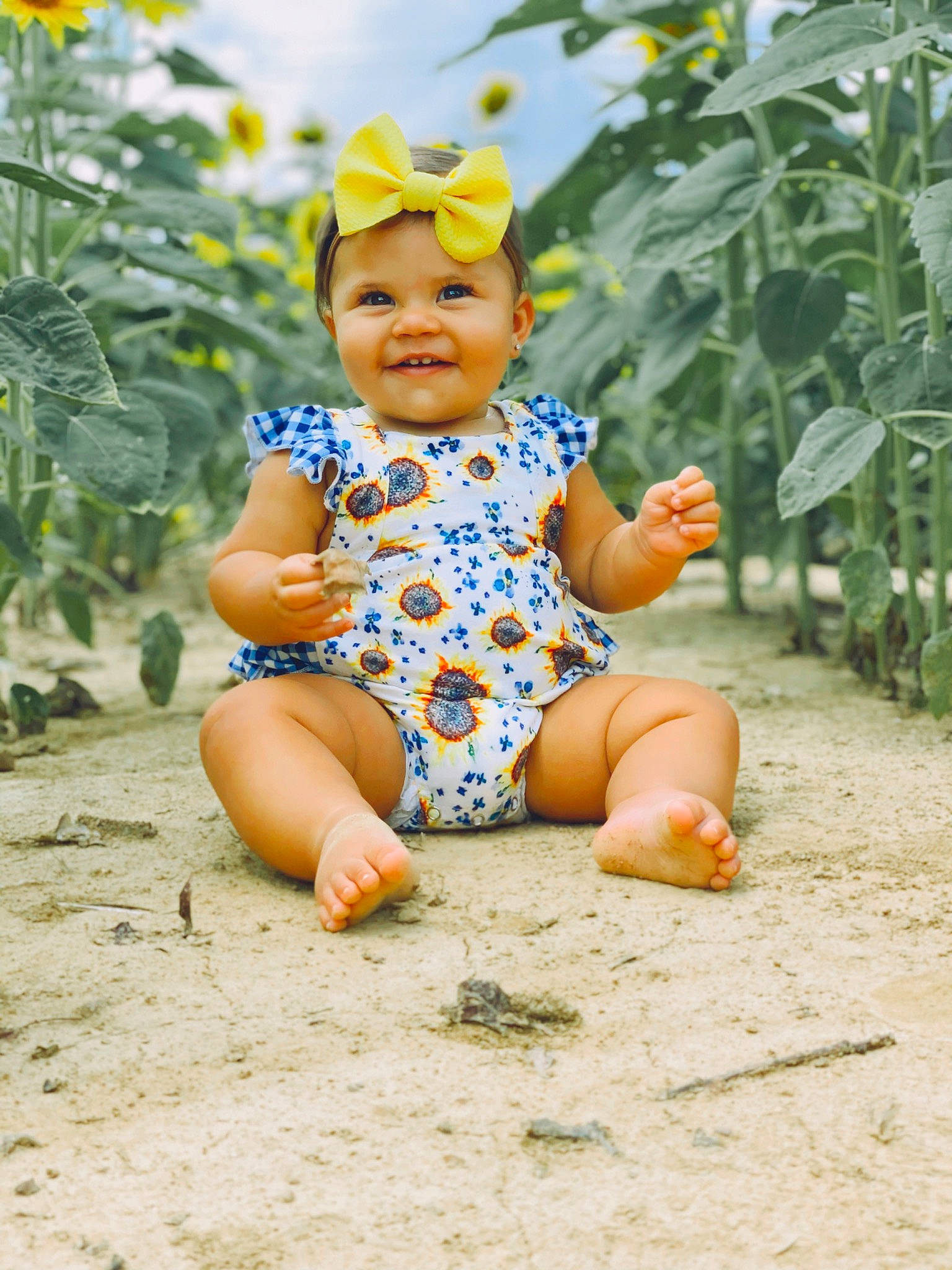 Jupiter is registered to the contest to win money with this photo: adaptation, baby, baby_toddler_clothing, barefoot, child, fun, headgear, headwear, joy, person, plant, play, sitting, smile, toddler, vacation, yellow