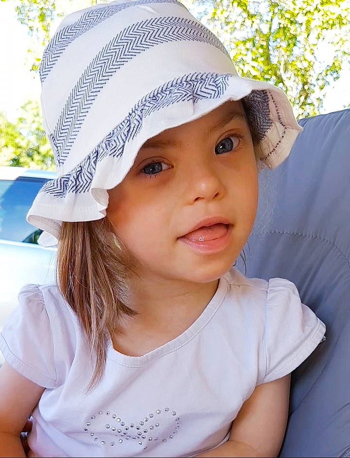 Lilly a rejoint le concours — aidez-le/la à gagner de superbes lots ! baby, bonnet, cap, child, clothing, fashion_accessory, hat, headgear, headwear, person, smile, sun_hat, toddler