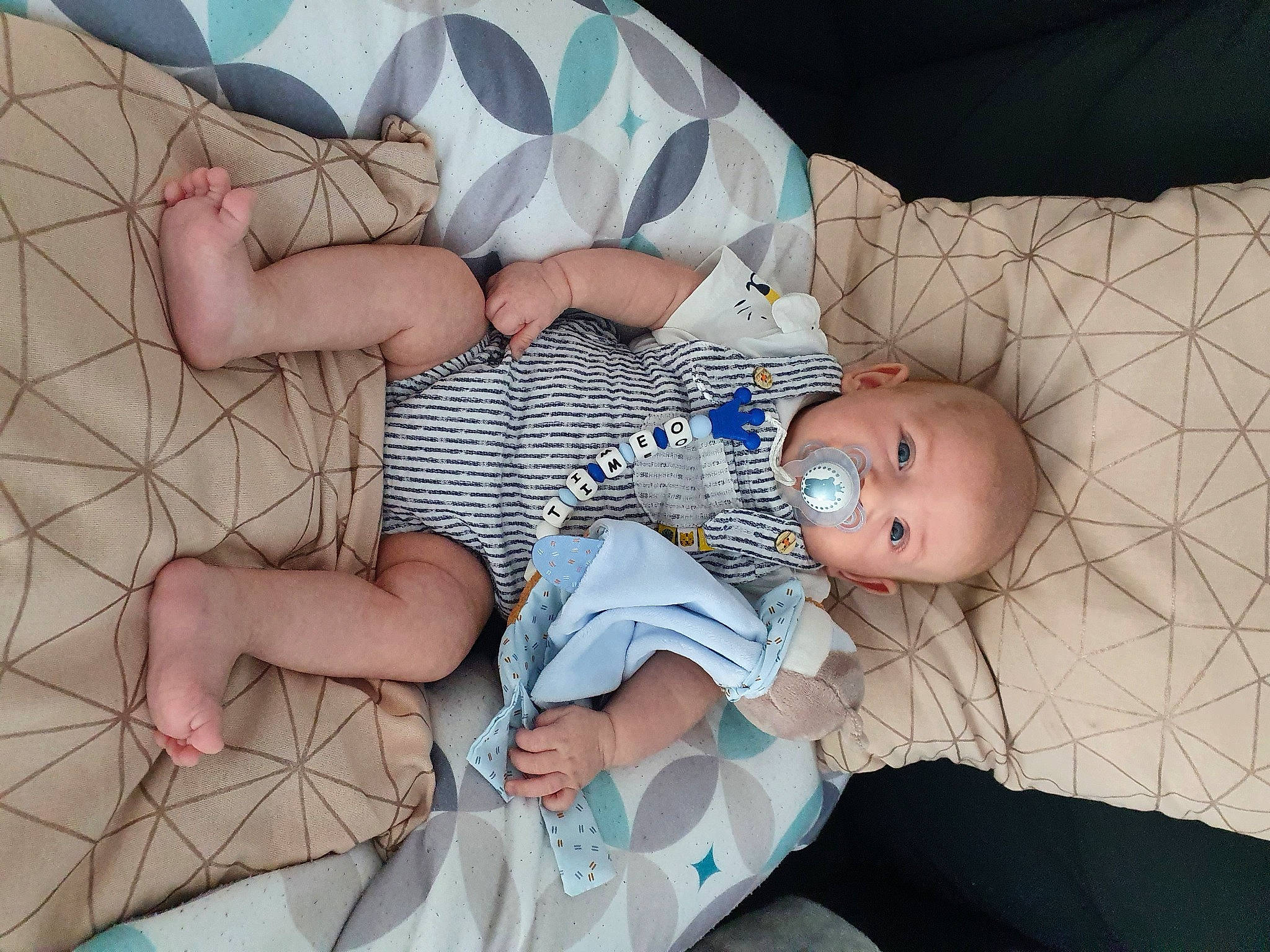 Timéo participe au concours pour gagner de l'argent avec cette photo : baby, baby_products, baby_toddler_clothing, child, comfort, dress, finger, foot, human_leg, joint, lap, leg, linens, mouth, pattern, person, product, skin, textile, thigh