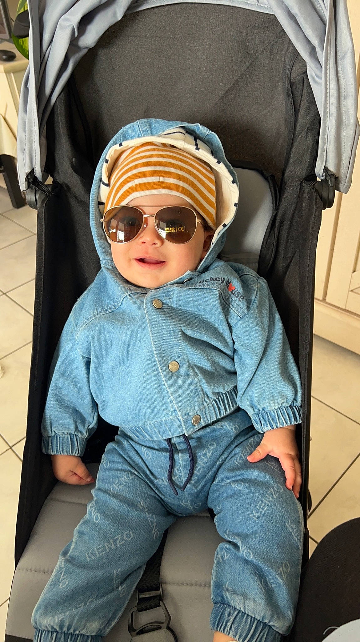 Naïl participe au concours pour gagner de l'argent avec cette photo : baby, baby_toddler_clothing, cap, car_seat, comfort, denim, electric_blue, eyewear, glasses, goggles, headgear, headwear, outerwear, person, personal_protective_equipment, sitting, sleeve, smile, sunglasses, toddler