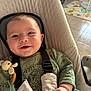 baby, smile, infant, baby_chair, green_clothing, knitted_toy, pacifier, straps, indoor, tile_floor, play_mat, happy, child, cute, hand, cushion, face, person, seated, home