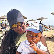 Mory participe au concours pour gagner de l'argent avec cette photo : baby, beach, cap, casual_clothing, child, family, hat, holding, outdoor, people, portrait, relaxation, sand, seaside, smile, summer, sunglasses, sunny, vacation, woman