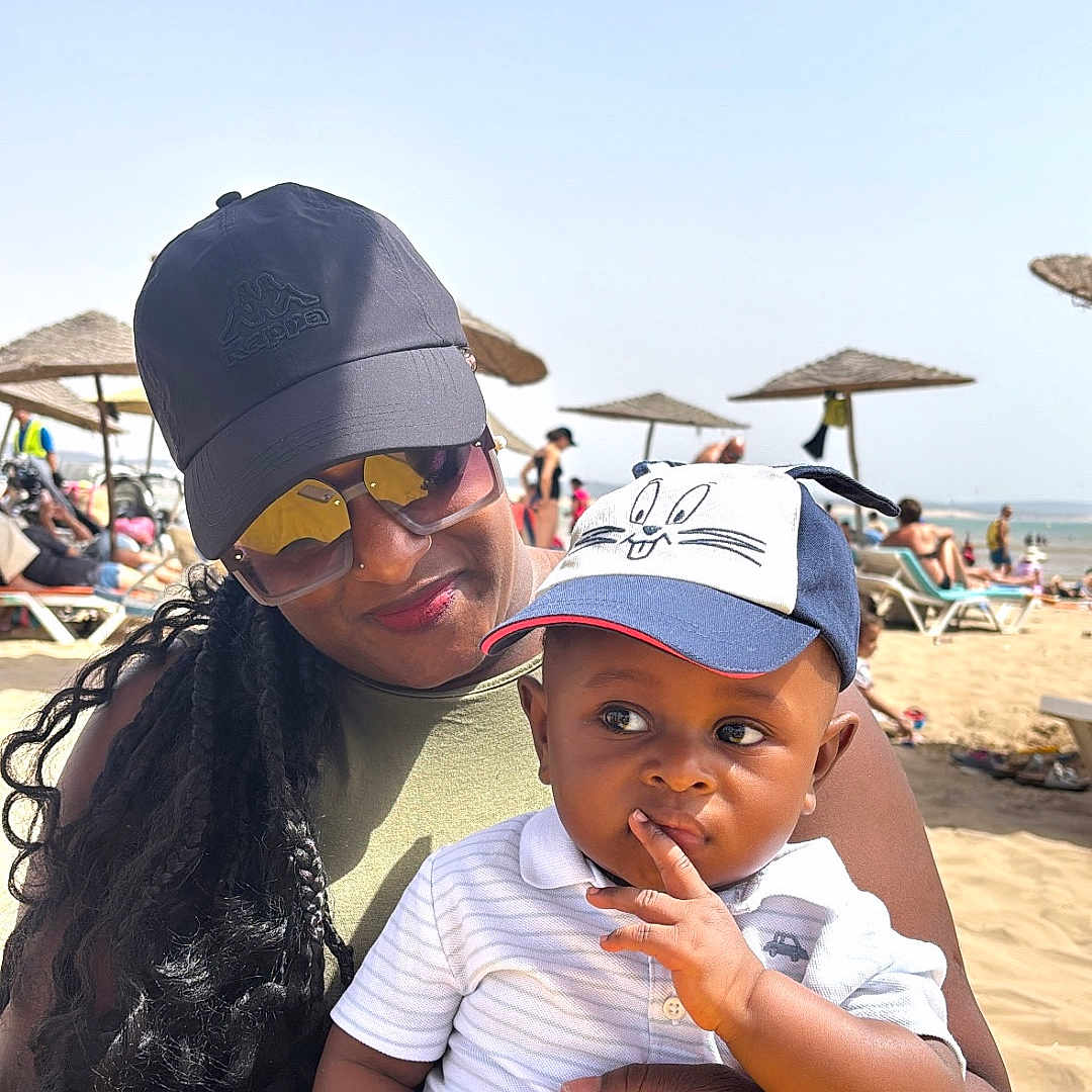 Mory participe au concours pour gagner de l'argent avec cette photo : baby, beach, cap, casual_clothing, child, family, hat, holding, outdoor, people, portrait, relaxation, sand, seaside, smile, summer, sunglasses, sunny, vacation, woman