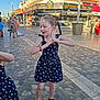 Maëlle participe au concours pour gagner de l'argent avec cette photo : child, girl, braid, dress, sandals, street, cobblestone, outdoor, daylight, market, people, building, shop, signage, urban, fashion, playful, side_view, person, sunlight