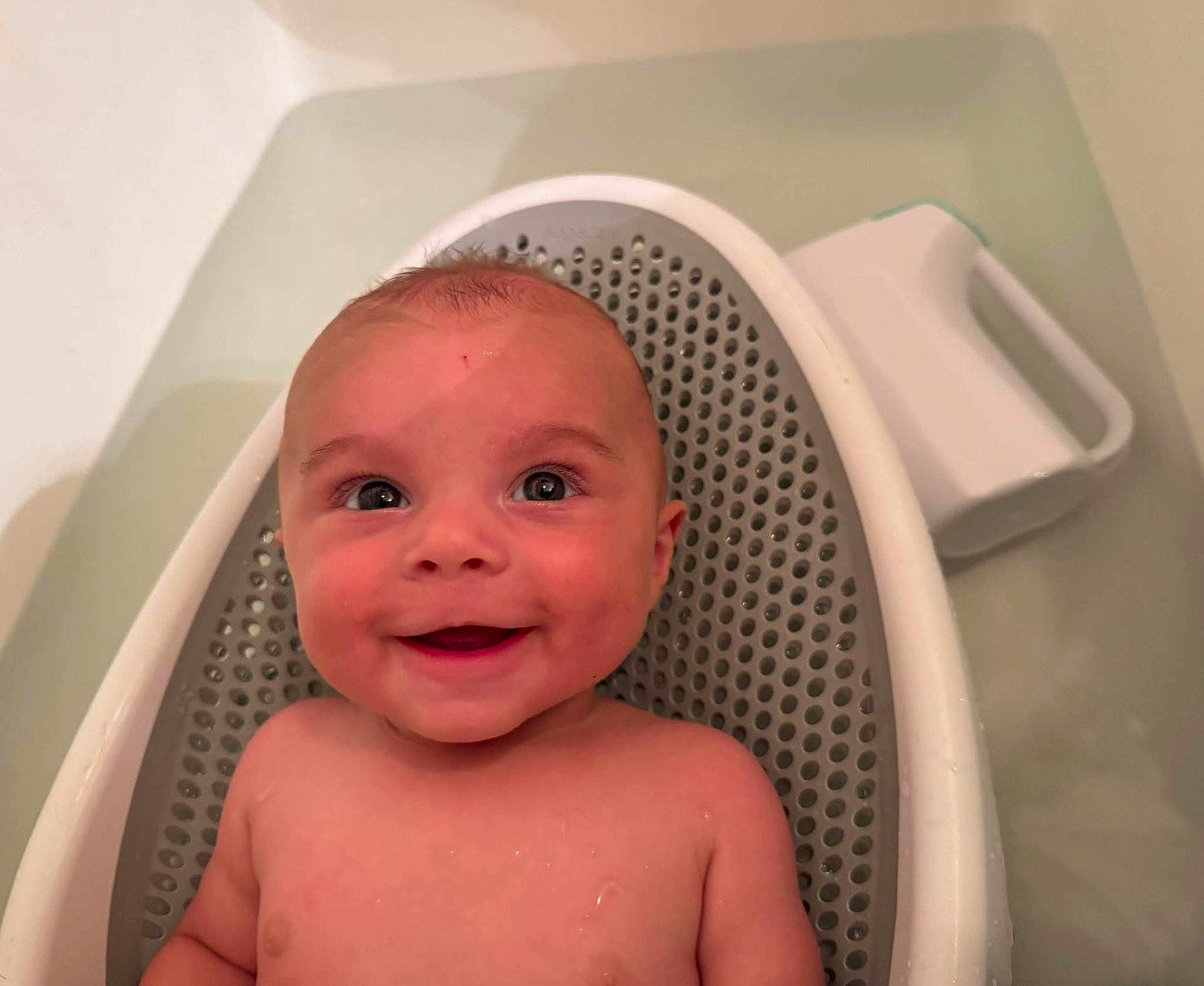 Crue is registered to the contest to win money with this photo: baby, smile, face, child, bathtub, bath, water, skin, infant, happy, relaxing, sitting, cute, young, indoors, person, head, shoulders, seat, plush