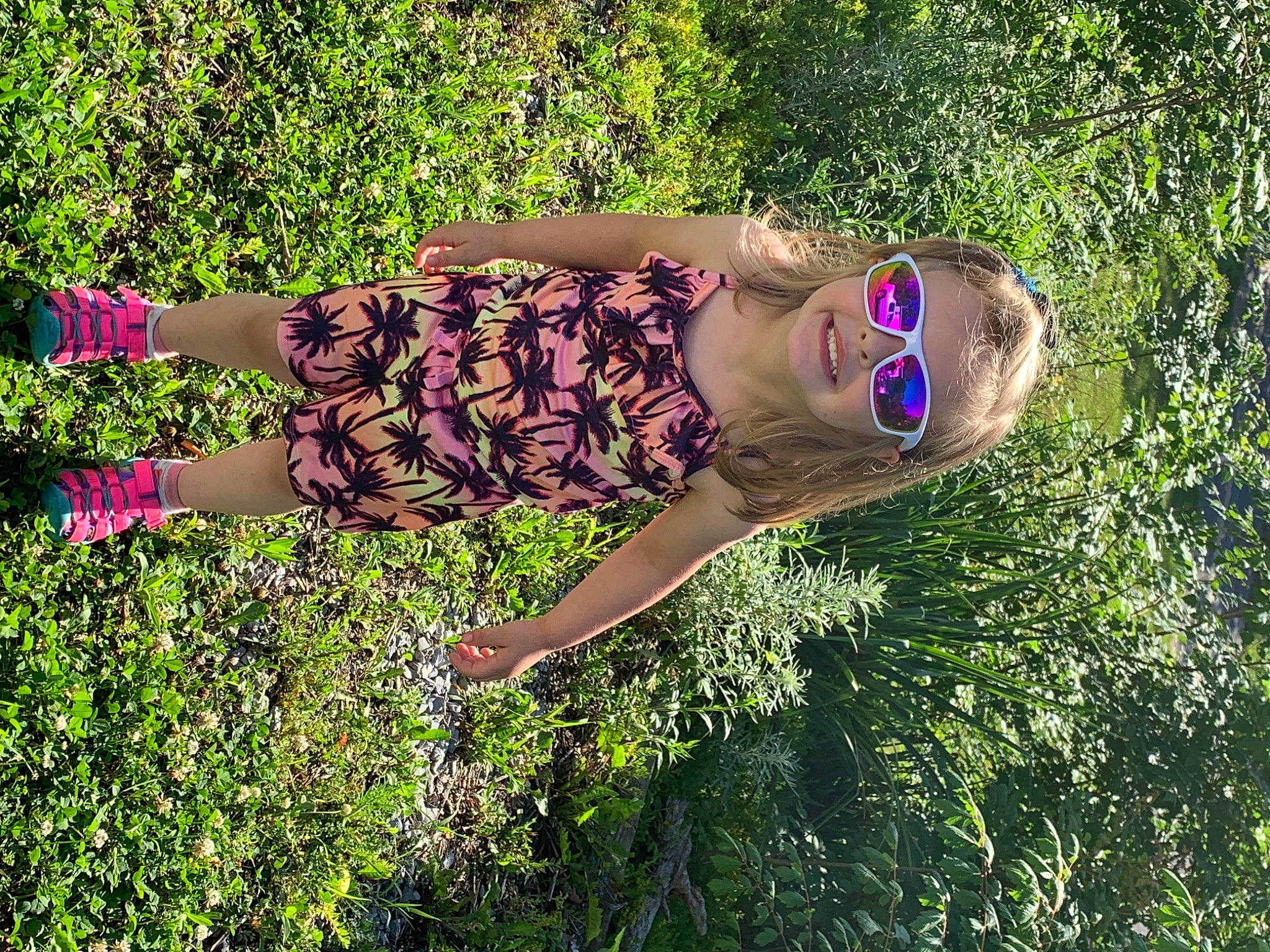 Teagan is registered to the contest to win money with this photo: eyewear, fun, grass, grass_family, grassland, happy, joy, landscape, leisure, meadow, morning, natural_environment, people_in_nature, person, plant, plant_community, shrub, sunglasses, sunlight, thigh