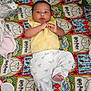 L'Eylah is registered to the contest to win money with this photo: baby, baby_brush, child, colorful, cozy, curious_expression, cute, fabric, harry_potter_blanket, indoors, infant, koala_print, lying_down, pacifier, patterned, person, portrait, soft_toys, white_pants, yellow_clothing