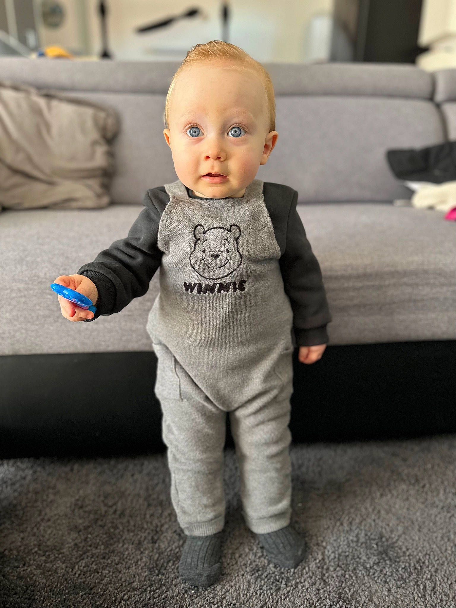 Angélo a rejoint le concours — aidez-le/la à gagner de superbes lots ! baby, baby_toddler_clothing, child, comfort, couch, eye, flooring, formal_wear, fur, grey, happy, leg, linens, person, room, sitting, sleeve, sportswear, surprise, t_shirt
