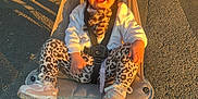 Rayah joined the competition — help win amazing prizes! child, toddler, stroller, outdoor, sunlight, smile, leopard_print, leggings, shoes, jacket, pavement, happy, baby, seatbelt, toy, pacifier, playful, daylight, person, wheel