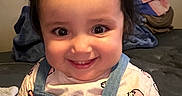 Amari is registered to the contest to win money with this photo: baby, bed, blanket, bow, cheerful, child, clothing, cute, denim, face, hair, happy, indoor, overalls, person, pile, portrait, smile, toddler, young
