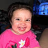 Amari is registered to the contest to win money with this photo: cartoon_graphic, child, clothing, cute, expression, eyes, face, fun, hair, happy, indoors, living_room, person, pink_shirt, portrait, sitting, smile, teeth, television, toddler