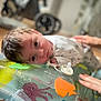 Xavier-James is registered to the contest to win money with this photo: baby, infant, child, tummy_time, water_mat, inflatable, aquatic_animals, octopus, fish, hand, tattoo, floor, indoor, curious, face, eyes, clothing, support, parent, blurred_background