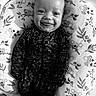 baby, smiling, infant, onesie, cushion, koala_pattern, lying_down, face, happy, child, portrait, black_and_white, cute, indoor, baby_clothes, young_child, cozy, expression, baby_boy, closeup