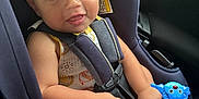 Finnley is registered to the contest to win money with this photo: baby, car_seat, child, toy, smiling, infant, seatbelt, cute, happy, indoors, safety, car_interior, child_safety, playful, young_child, clothing, hands, feet, closeup, portrait