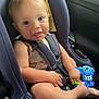 baby, car_seat, child, toy, smiling, infant, seatbelt, cute, happy, indoors, safety, car_interior, child_safety, playful, young_child, clothing, hands, feet, closeup, portrait
