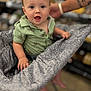 Finnley joined the competition — help win amazing prizes! toddler, child, shopping_cart, green_shirt, short_sleeves, patterned_fabric, tattooed_arm, indoor, store, aisle, blurred_background, happy, smiling, person, face, barefoot, light_skin, blonde_hair, casual_clothing, supporting_hand