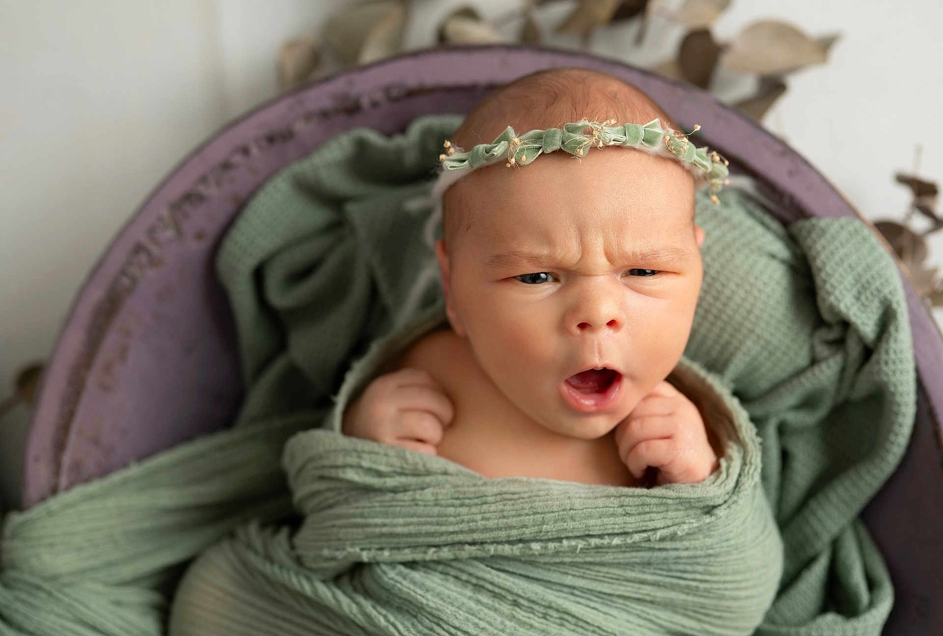 Iris a rejoint le concours — aidez-le/la à gagner de superbes lots ! baby, newborn, infant, wrapped, blanket, headband, flower_crown, green, portrait, cute, expression, face, hands, soft_texture, cozy, indoor, closeup, skin, child, adorable