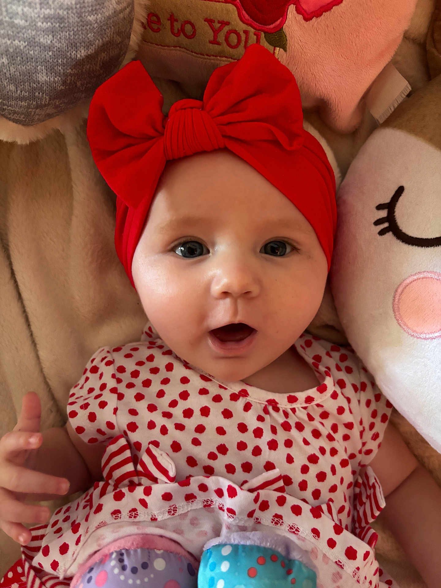 Kamélia participe au concours pour gagner de l'argent avec cette photo : baby, infant, red_bow, headband, polka_dot, dress, plush_toy, blanket, soft_toy, cute, child, smiling, face, portrait, indoors, cozy, comfort, happy, expression, small_hand
