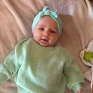 Kamélia a rejoint le concours — aidez-le/la à gagner de superbes lots ! baby, blanket, child, clothing, comfort, cozy, cute, face, hand, headband, indoors, infant, lying_down, mint_green, person, portrait, smiling, soft, sweater, toy