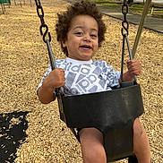 King joined the competition — help win amazing prizes! toddler, child, swing, playground, outdoor, smiling, curly_hair, wood_chips, trees, flowers, fence, chains, shoes, clothing, happy, person, park, daylight, adidas, seat