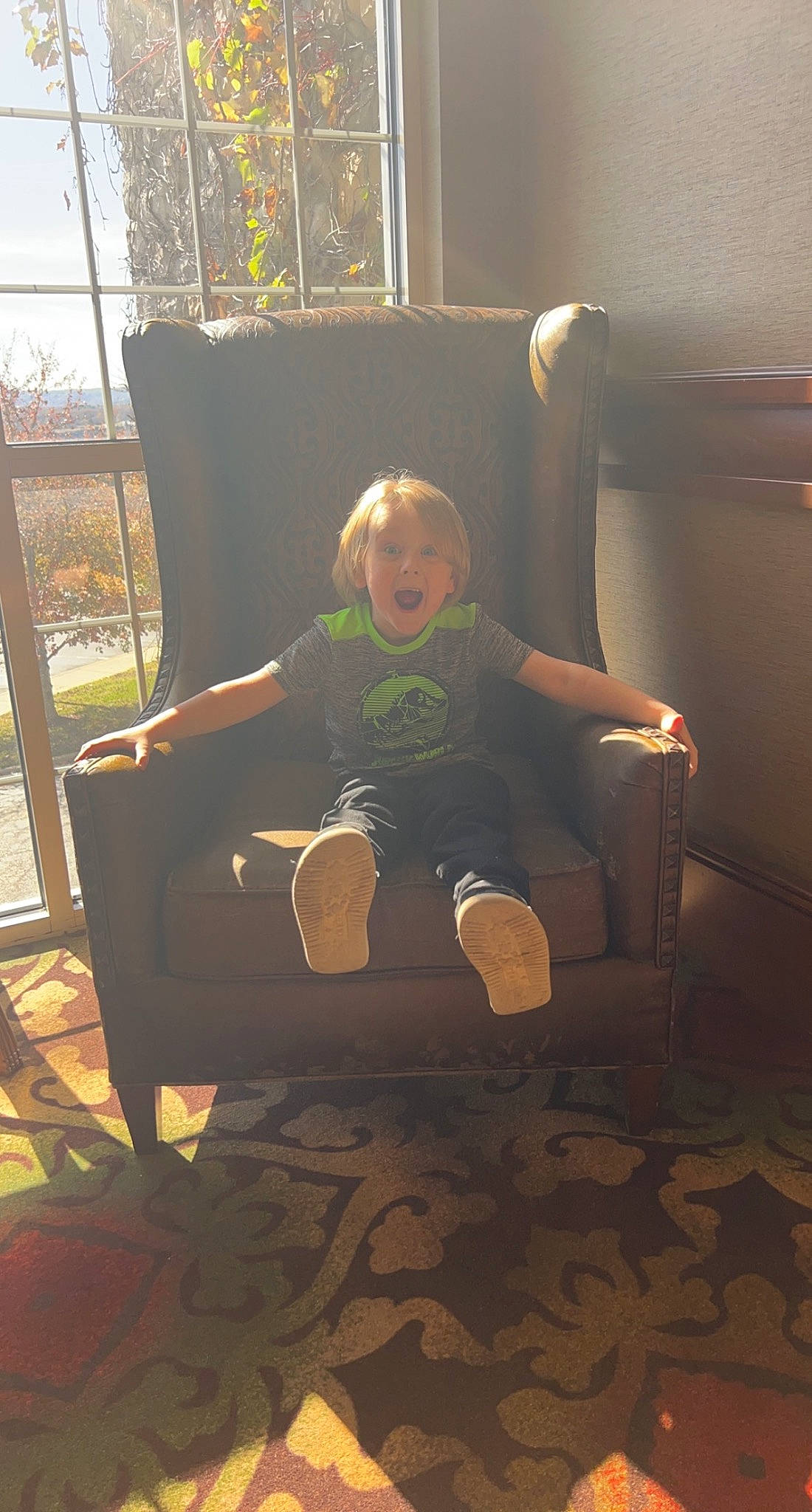 Braxton joined the competition — help win amazing prizes! baby, chair, child, comfort, floor, flooring, foot, fun, hardwood, human_leg, knee, leisure, person, room, sitting, sneakers, surprise, t_shirt, thigh, tints_and_shades