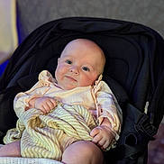 Dolcey joined the competition — help win amazing prizes! baby, infant, stroller, blanket, clothing, face, person, child, cute, smile, skin, hand, leg, indoors, seat, soft_lighting, pastel_colors, comfort, portrait, young_child
