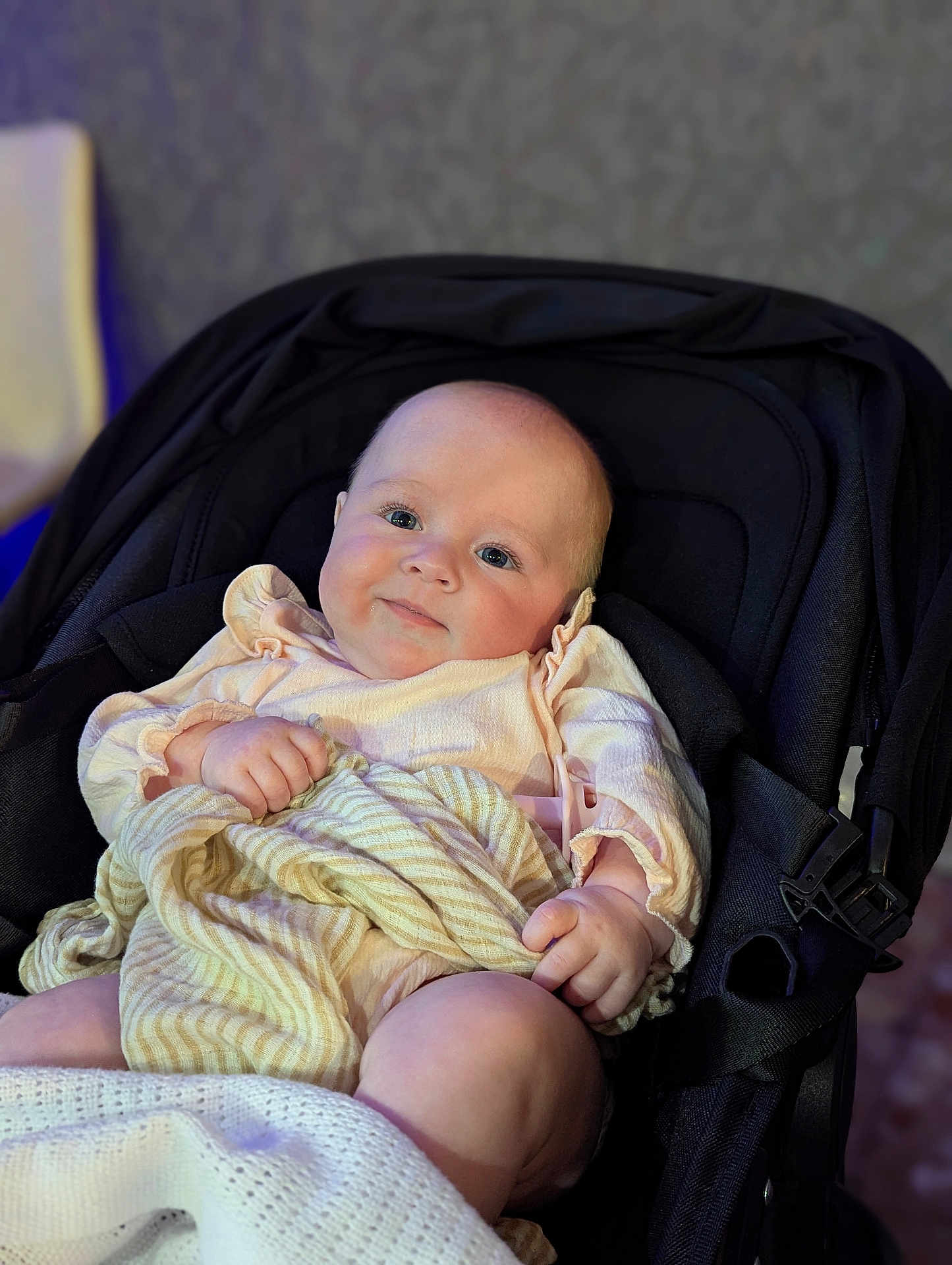 Dolcey joined the competition — help win amazing prizes! baby, infant, stroller, blanket, clothing, face, person, child, cute, smile, skin, hand, leg, indoors, seat, soft_lighting, pastel_colors, comfort, portrait, young_child