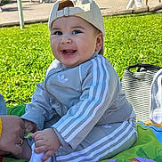 Zayn participe au concours pour gagner de l'argent avec cette photo : baby, child, smiling, outdoor, grass, cap, tracksuit, adidas, play_mat, hand, person, happy, sitting, toy, colorful, sunlight, park, casual_clothing, infant, cute