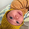 baby, infant, face, blue_eyes, knitted_hat, yellow_hat, yellow_clothing, blanket, soft_texture, close_up, cute, child, portrait, newborn, lying_down, warm_clothing, indoor, skin, expression, adorable