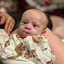 baby, infant, face, tongue, blue_eyes, clothing, animal_print, hand, leg, person, portrait, closeup, cute, indoor, soft_focus, skin, expression, newborn, cozy, warm