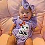 Willow joined the competition — help win amazing prizes! baby, child, smile, purple_outfit, headband, bow, ghost_design, text_on_clothing, pink_cushion, soft_furniture, sitting, happy, infant, cute, indoors, portrait, clothing, baby_fashion, closeup, person