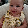 baby, infant, smiling, cute, yellow_dress, bee_pattern, soft_cushion, indoors, happy, portrait, child, person, closeup, cheerful, young, skin, hand, head, eyes, expression