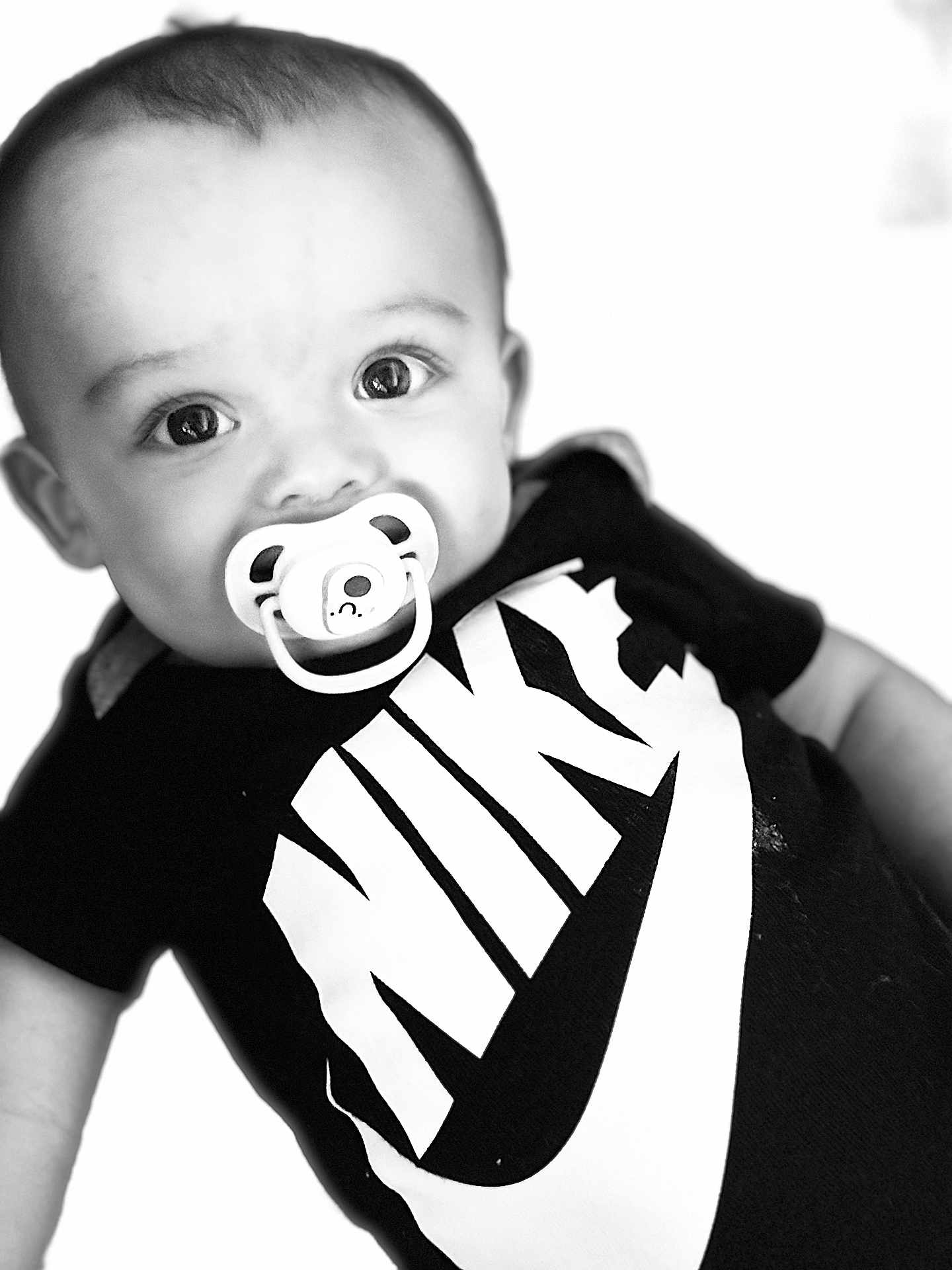 Lystiano a rejoint le concours — aidez-le/la à gagner de superbes lots ! baby, black_and_white, child, closeup, clothing, cute, expression, eyes, face, head, infant, logo, monochrome, nike, pacifier, person, portrait, studio, tshirt, young