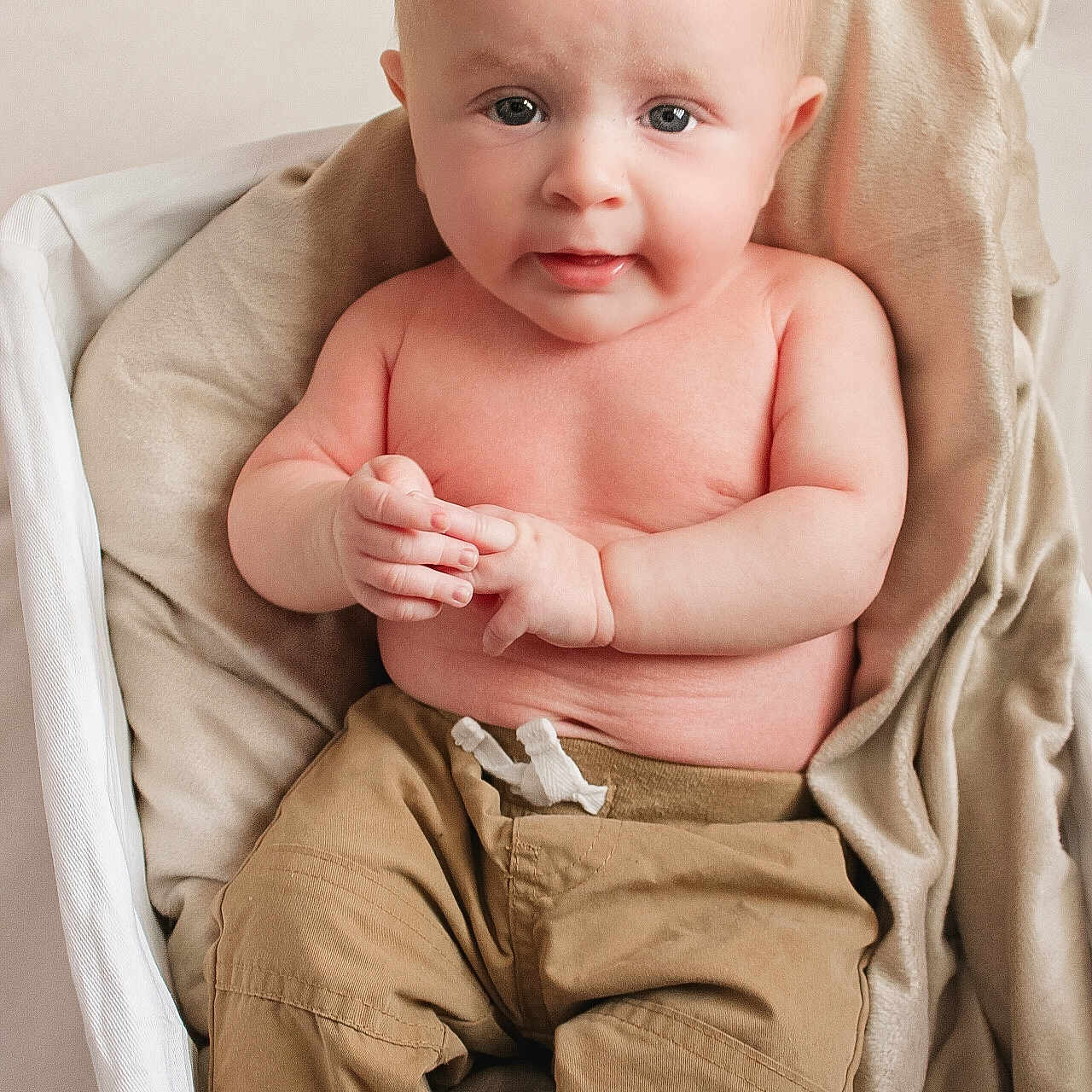 Clayton is registered to the contest to win money with this photo: baby, bare_chest, basket, beige, blanket, child, comfort, cute, expression, face, hands, indoor, infant, newborn, pants, portrait, sitting, skin, soft_lighting, young