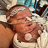 baby, infant, hospital, medical_equipment, nasal_cannula, sensor_pads, blanket, sleeping, patient, healthcare, newborn, face, head, tubes, monitoring, skin, person, resting, care, medical